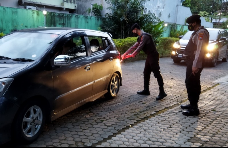 Petugas saat melakukan pengecekan kendaraan Petugas saat melakukan pengecekan kendaraan sebelum masuk area parkir Gereja.