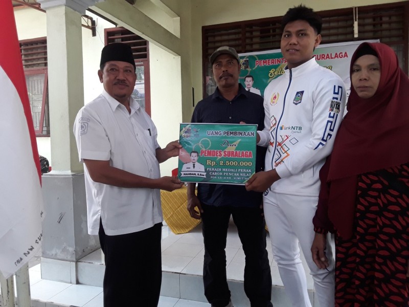 Foto Senyum Bamgga Kades Suralaga, Mahdan, S.Sos saat Memberikan Dana Apriasi kepada Peraih Medali Perak PON XXI Aceh Cabor Pencak Silat atas nama M. Padil Anwar pada Rabu (18/9/2024) di Kantor Desa Suralaga (Dok. Pribadi)