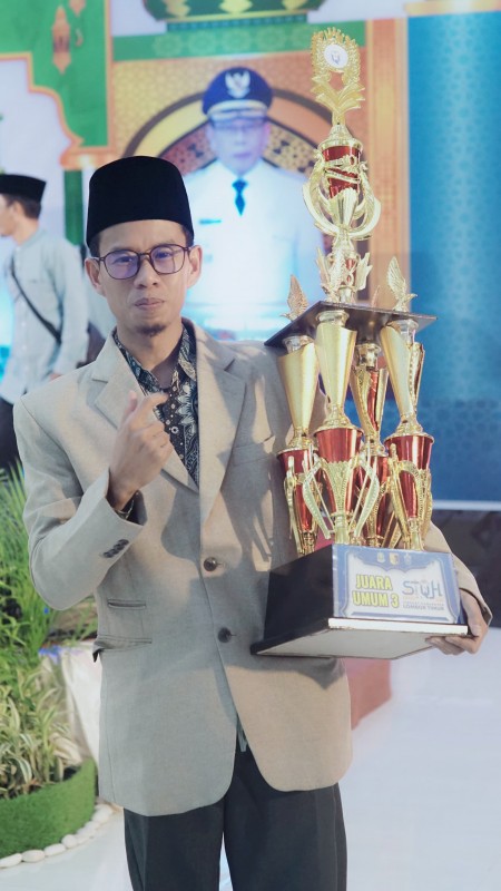 Foto Pengurus Ponpes DIBAMA Aikmel, Ust. Eka Budiansyah, SQ., S.Pd saat Menerima Piala Juara Umum 3 dalam STQH XXVIII Tingkat Lotim Tahun 2025
