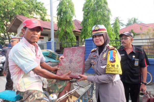Bersama Sekretaris Kesbangpol Inhil, Kasat Lantas Bagi-bagi Bunga dan Sembako