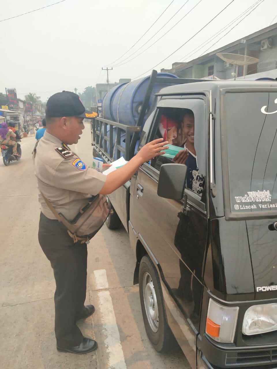 Cegah ISPA, Mahmud Personel Polsek Kemuning Bagi-bagi Masker Kepada Masyarakat